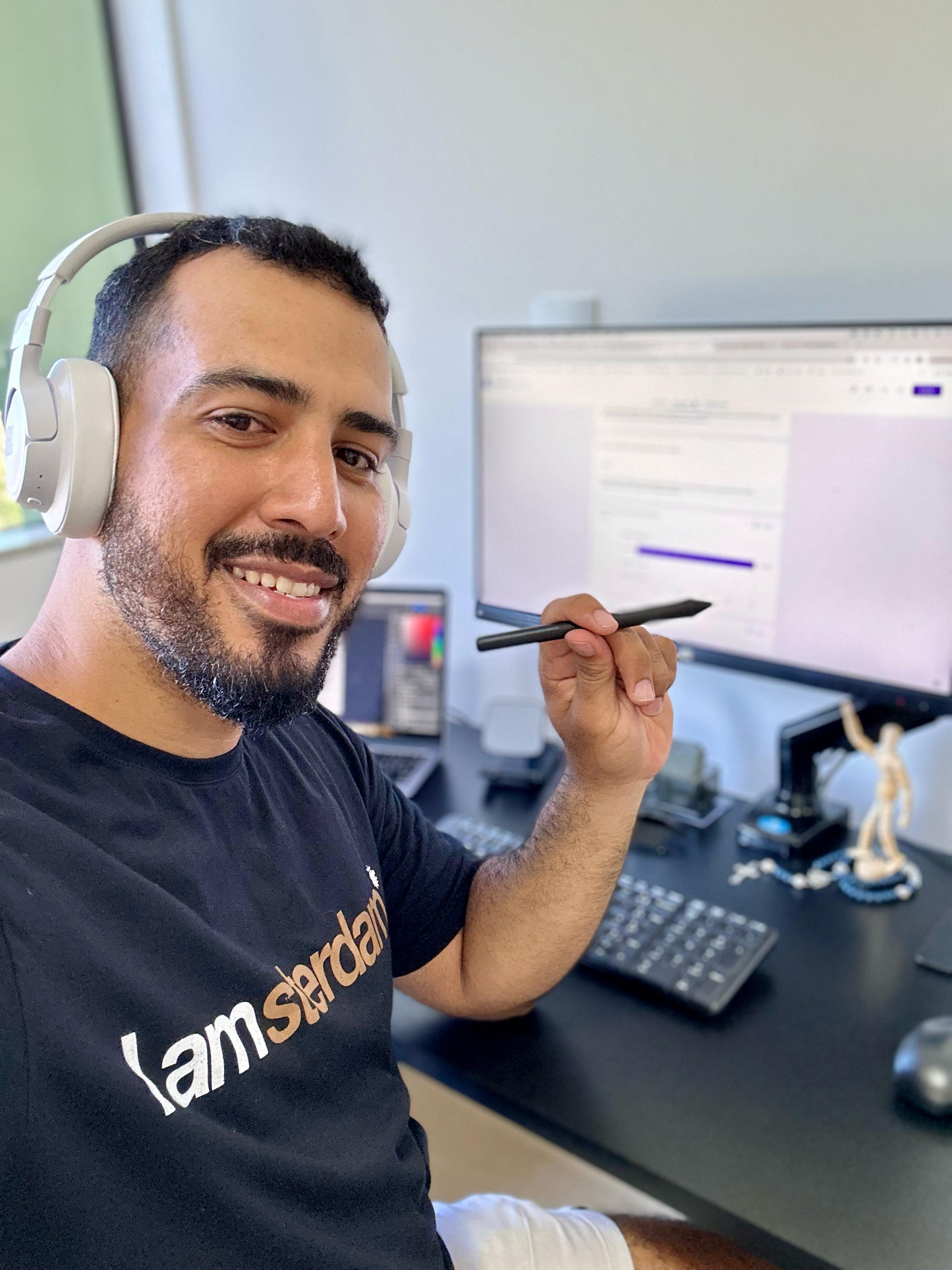 Wesley Palmer com fones de ouvido e caneta de mesa digitalizadora no ambiente de trabalho